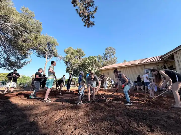 הורים וילדים עובדים יחד בחצר ביום עבודה קהילתי